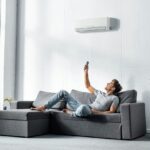 handsome-man-lying-on-sofa-and-switching-on-air-conditioner.jpg